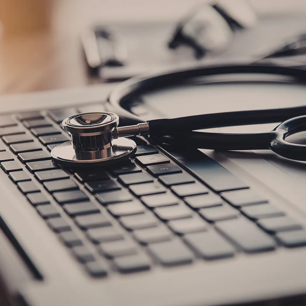 Un stéthoscope posé sur le clavier d'un ordinateur portable