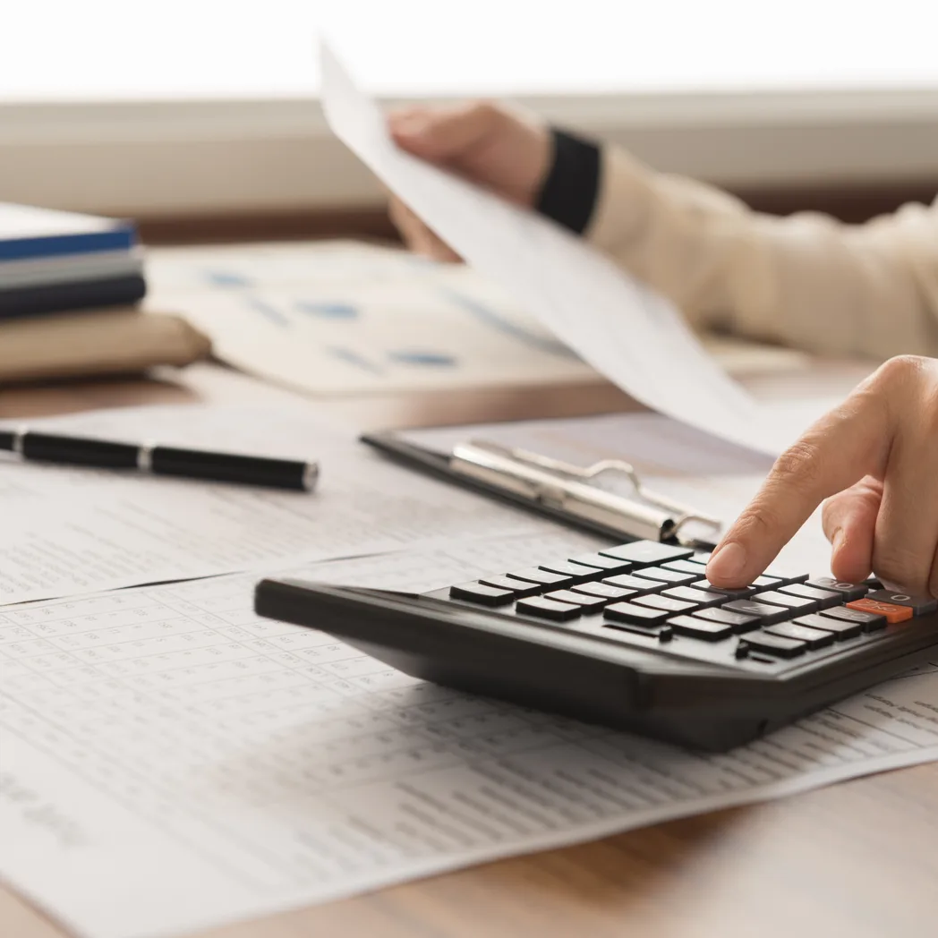 Saisie d’un montant à la calculatrice devant des états comptables imprimés