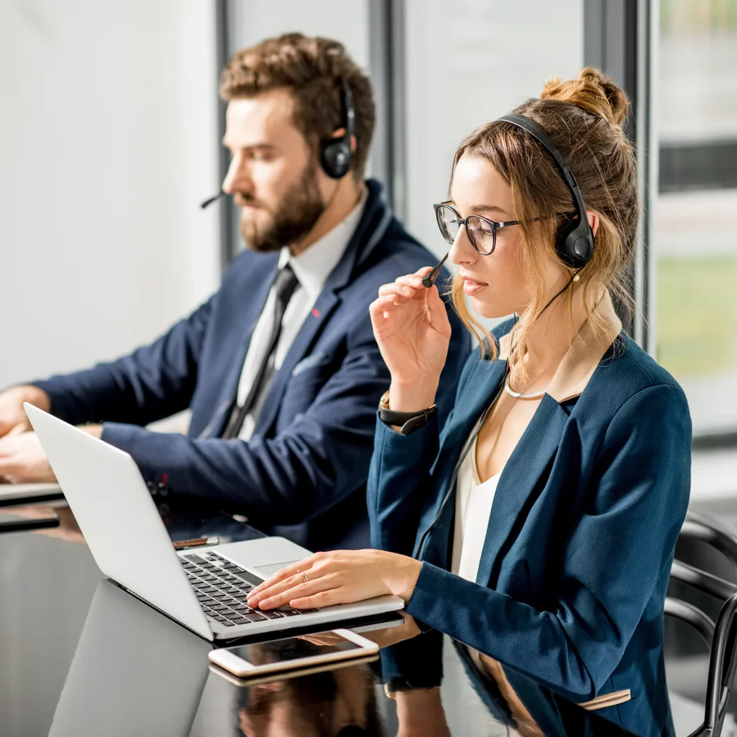 Deux conseillers avec casque micro à leur poste de travail