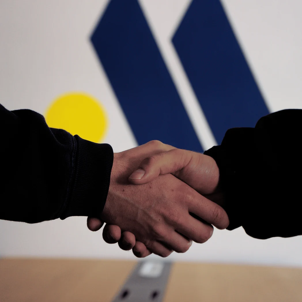 Une poignée de main devant le logo Marcea